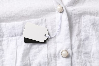 Photo of Cardboard tags on white shirt, top view