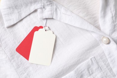 Photo of Cardboard tags on white shirt, top view