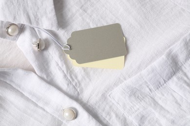 Photo of Cardboard tags on white shirt, top view