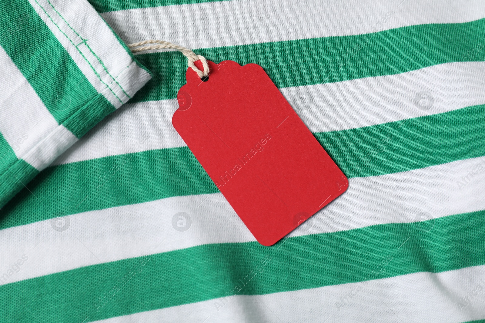 Cardboard tag on striped garment, top view Photo of Cardboard tag on striped garment, top view