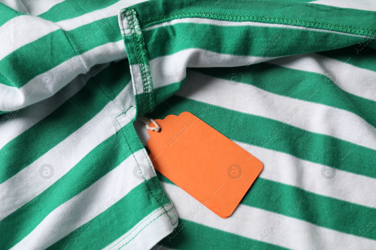 Cardboard tag on striped garment, top view Photo of Cardboard tag on striped garment, top view