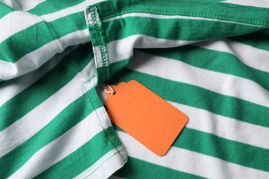 Photo of Cardboard tag on striped garment, top view