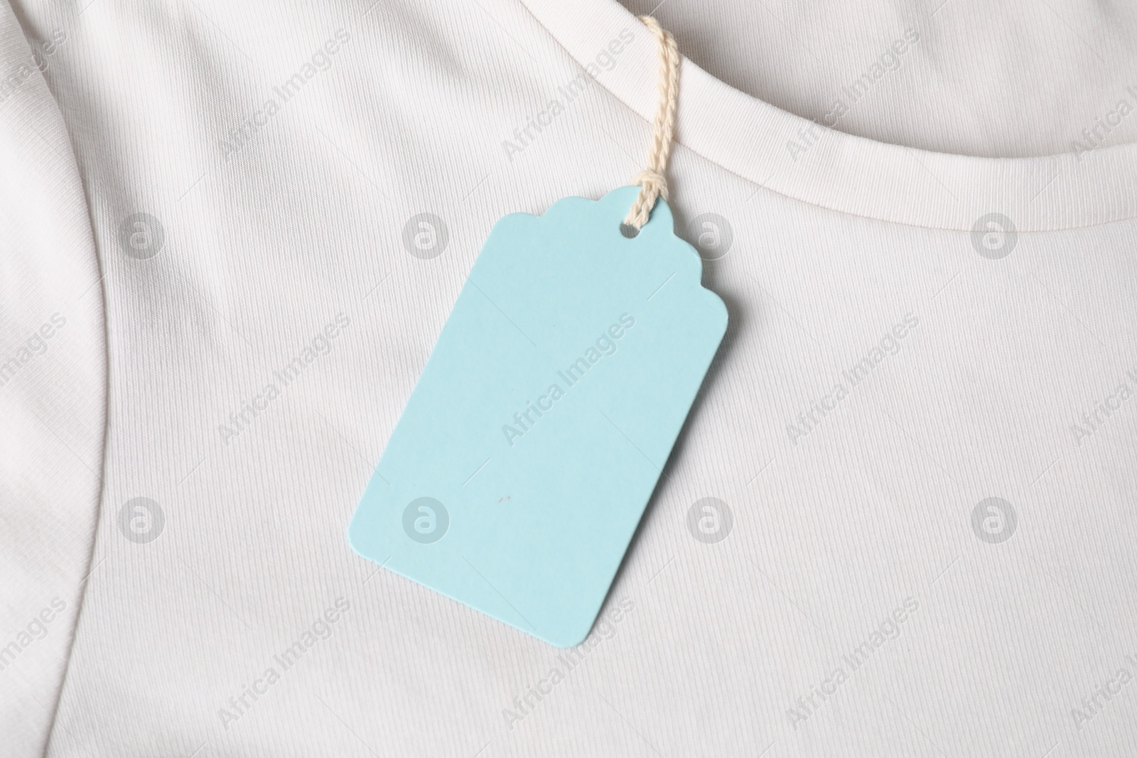 Cardboard tag on white t-shirt, top view Photo of Cardboard tag on white t-shirt, top view