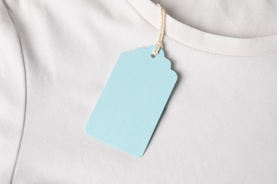 Photo of Cardboard tag on white t-shirt, top view