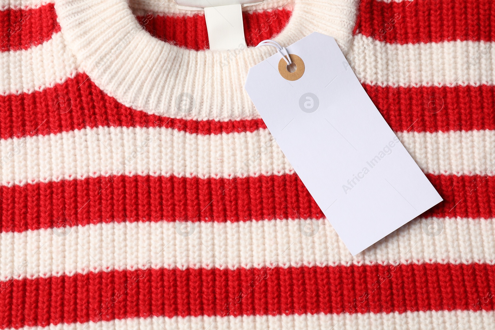 Cardboard tag on knitted sweater, top view Photo of Cardboard tag on knitted sweater, top view