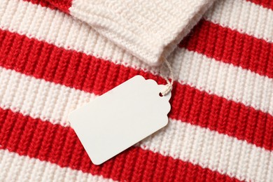 Photo of Cardboard tag on knitted sweater, top view
