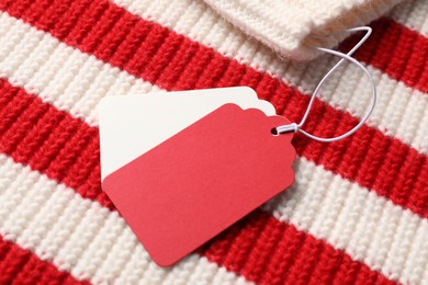 Photo of Cardboard tags on knitted sweater, above view