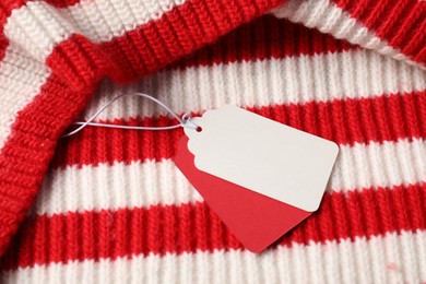 Photo of Cardboard tags on knitted sweater, above view