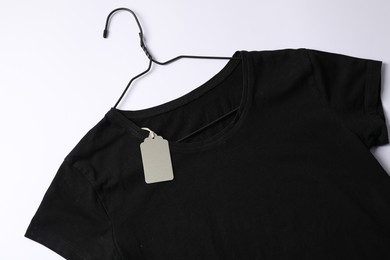 Photo of T-shirt with tag on white background, top view