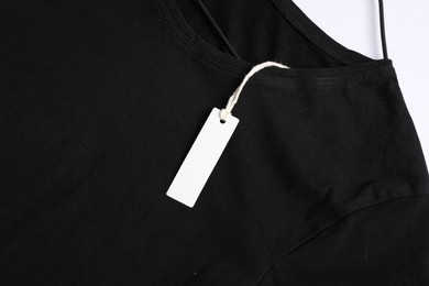 Photo of T-shirt with tag on white background, top view
