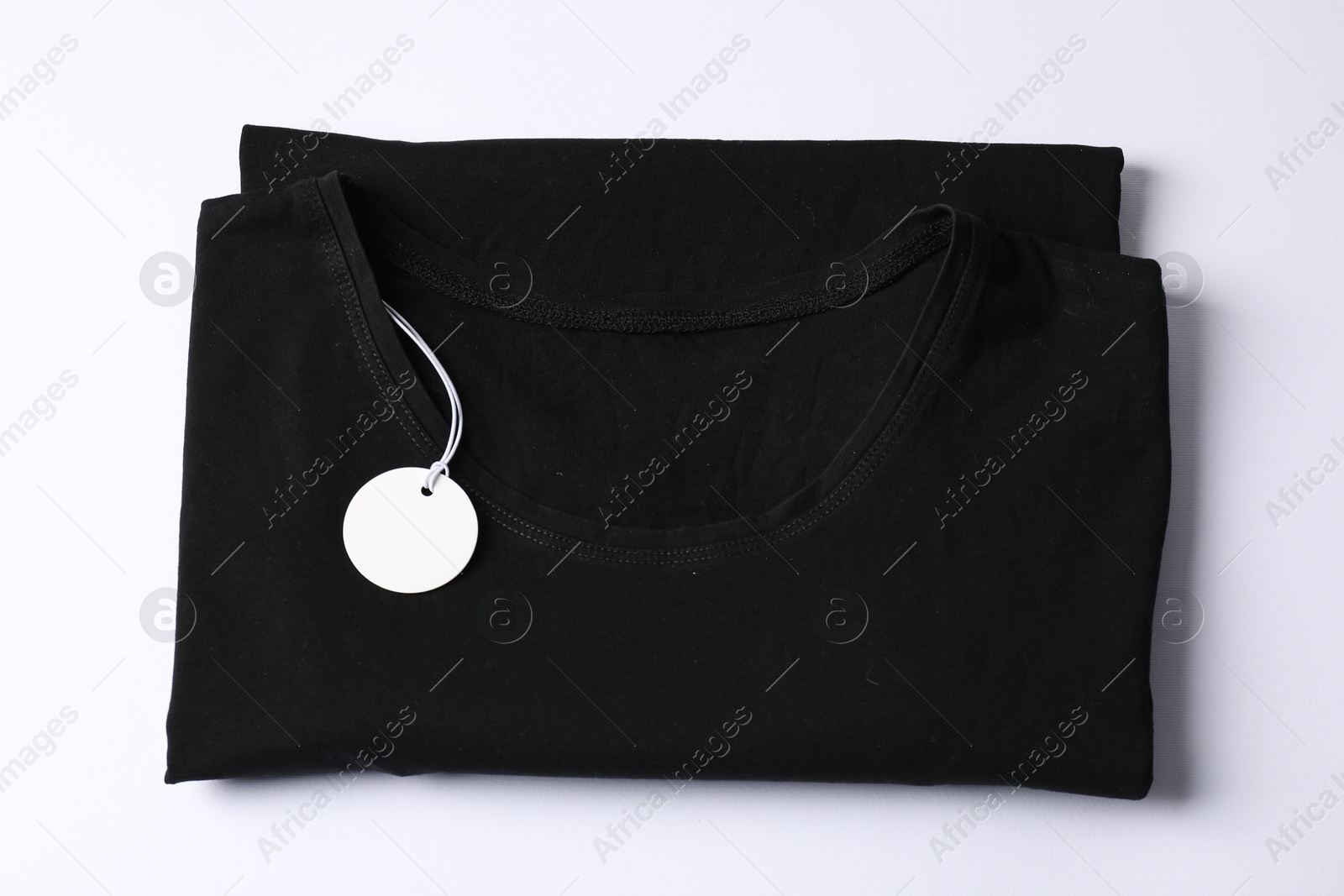T-shirt with tag on white background, top view Photo of T-shirt with tag on white background, top view