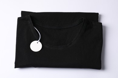 Photo of T-shirt with tag on white background, top view
