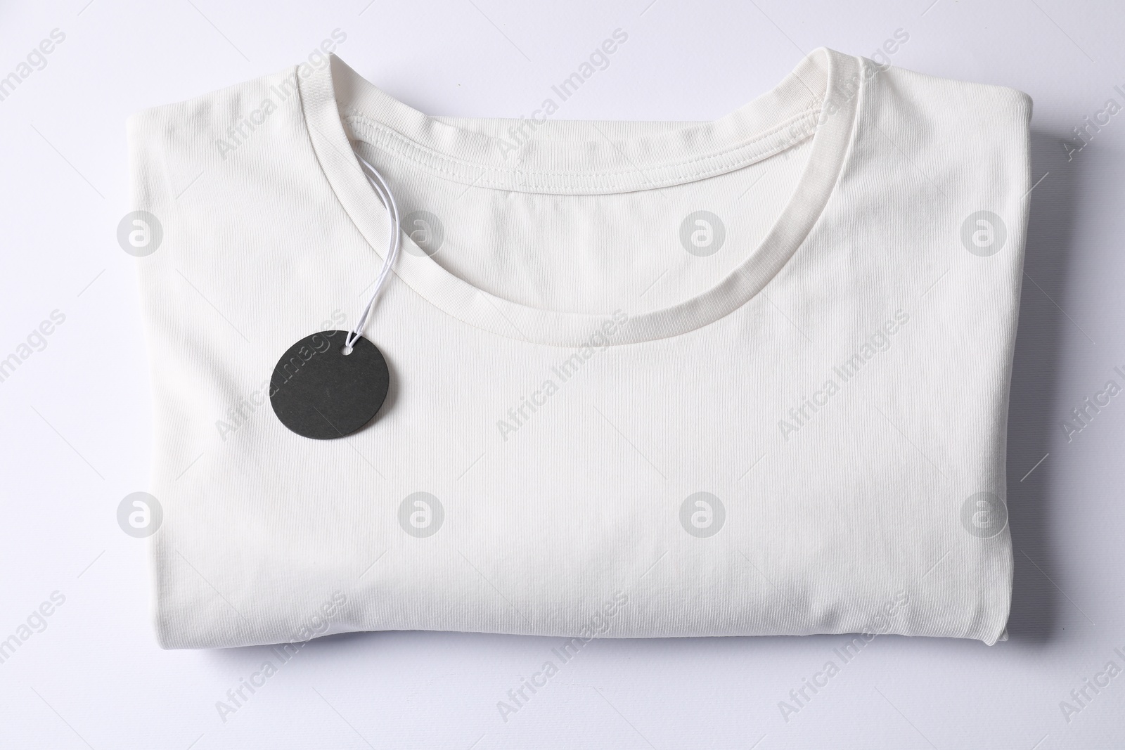 T-shirt with tag on white background, top view Photo of T-shirt with tag on white background, top view