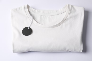 Photo of T-shirt with tag on white background, top view