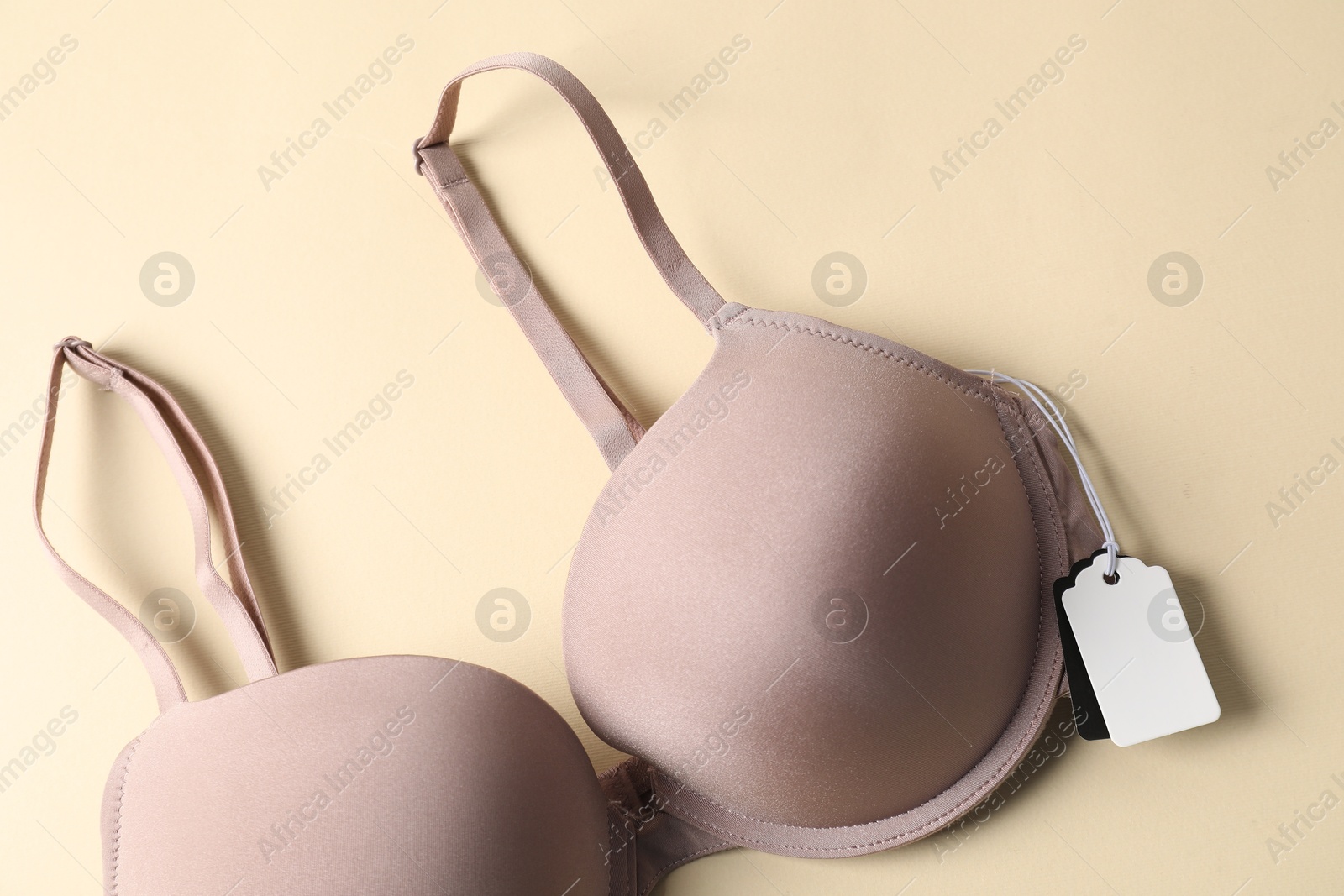 Bra with tag on beige background, top view Photo of Bra with tag on beige background, top view
