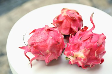 Photo of Delicious pitaya fruits on white table outdoors, closeup