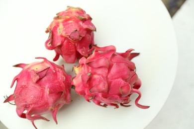 Photo of Delicious pitaya fruits on white table outdoors, above view