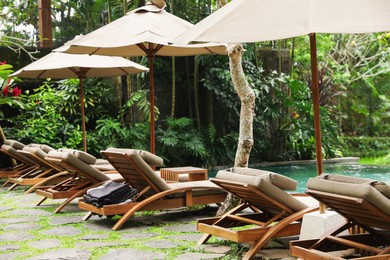Photo of Empty sunbeds near pool at luxury resort