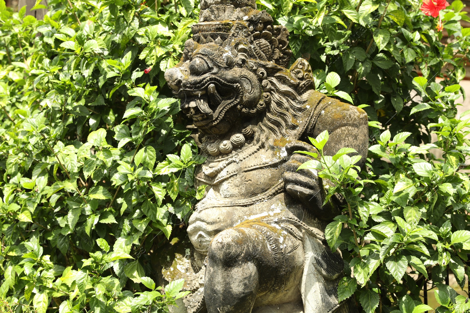 Bali, Indonesia - May 15, 2025: Beautiful ancient sculpture surrounded by green plants outdoors Photo of Bali, Indonesia - May 15, 2025: Beautiful ancient sculpture surrounded by green plants outdoors