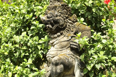 Photo of Bali, Indonesia - May 15, 2025: Beautiful ancient sculpture surrounded by green plants outdoors