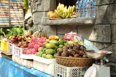 Photo of Bali, Indonesia - May 15, 2025: Fresh ripe fruits near stone building at market
