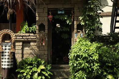Photo of Bali, Indonesia - May 15, 2025: Stone arch entrance decorated with traditional ornaments and green plants outdoors