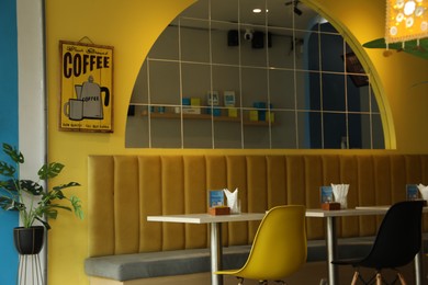 Photo of Bali, Indonesia - May 15, 2025: Stylish tables and chairs in cozy cafe interior