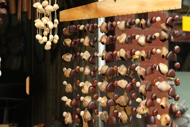 Photo of Different wind chimes in outdoor souvenir shop, closeup