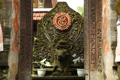 Photo of Bali, Indonesia - May 15, 2025: Beautiful ancient ornate sculpture on city street