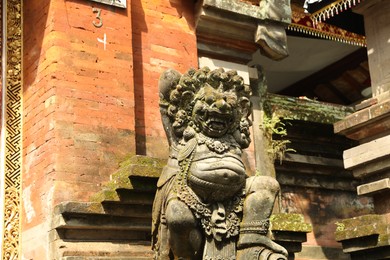 Photo of Bali, Indonesia - May 15, 2025: Beautiful ancient sculpture on city street, low angle view