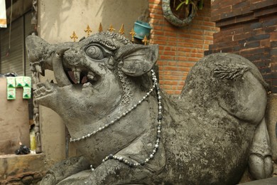 Photo of Bali, Indonesia - May 15, 2025: Beautiful ancient sculpture of boar on city street