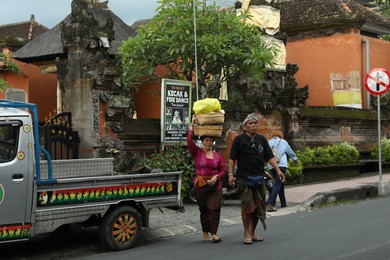Photo of Bali, Indonesia - May 15, 2025: Locals in traditional clothes walking on street