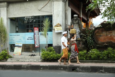 Photo of Bali, Indonesia - May 15, 2025: Locals in traditional clothes walking on street