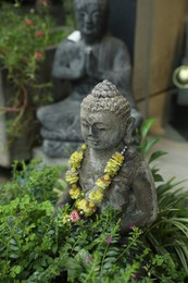Photo of Bali, Indonesia - May 15, 2025: Beautiful Buddha statue surrounded by green plants outdoors