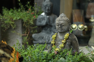 Photo of Bali, Indonesia - May 15, 2025: Beautiful Buddha statue surrounded by green plants outdoors