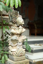 Photo of Bali, Indonesia - May 15, 2025: Beautiful ancient sculpture near entrance of building outdoors