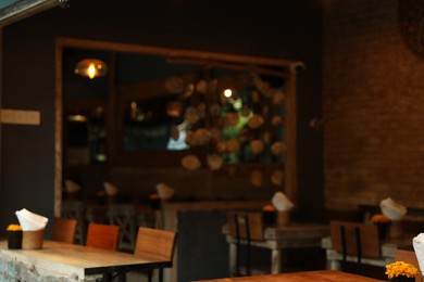 Photo of Blurred view of tables, chairs and decor in cozy cafe interior
