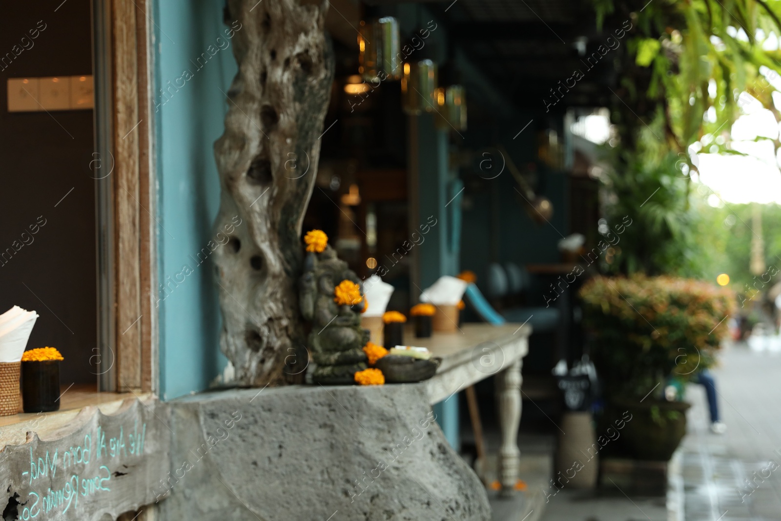 Beautiful Ganesha statue with ornament on cafe counter outdoors Photo of Beautiful Ganesha statue with ornament on cafe counter outdoors