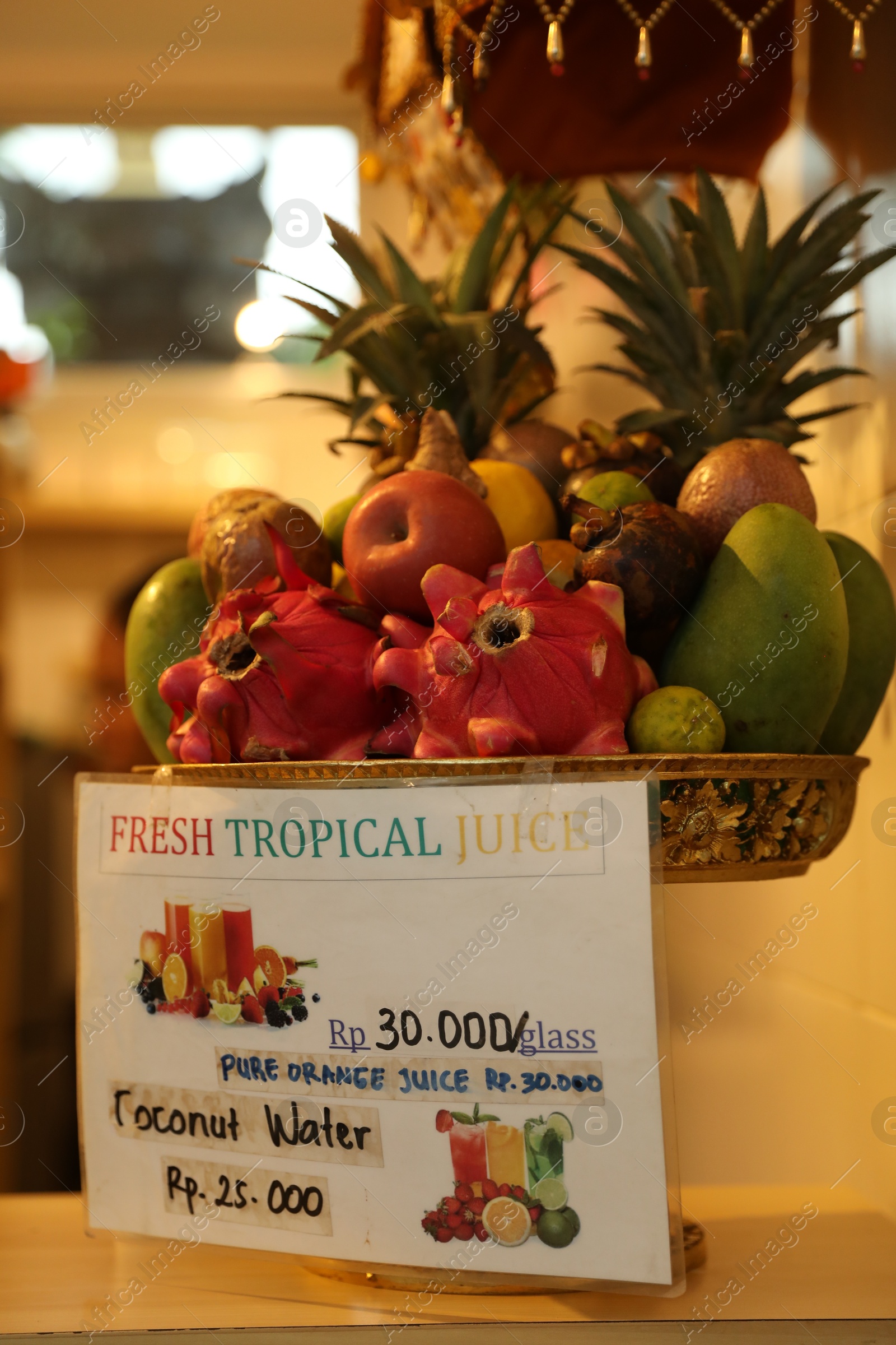 Bali, Indonesia - May 15, 2025: Different tropical fruits for making juice and card with price indoors, closeup Photo of Bali, Indonesia - May 15, 2025: Different tropical fruits for making juice and card with price indoors, closeup
