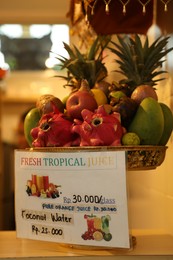 Photo of Bali, Indonesia - May 15, 2025: Different tropical fruits for making juice and card with price indoors, closeup