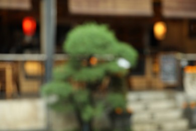 Photo of Blurred view of street with cafe and green plant