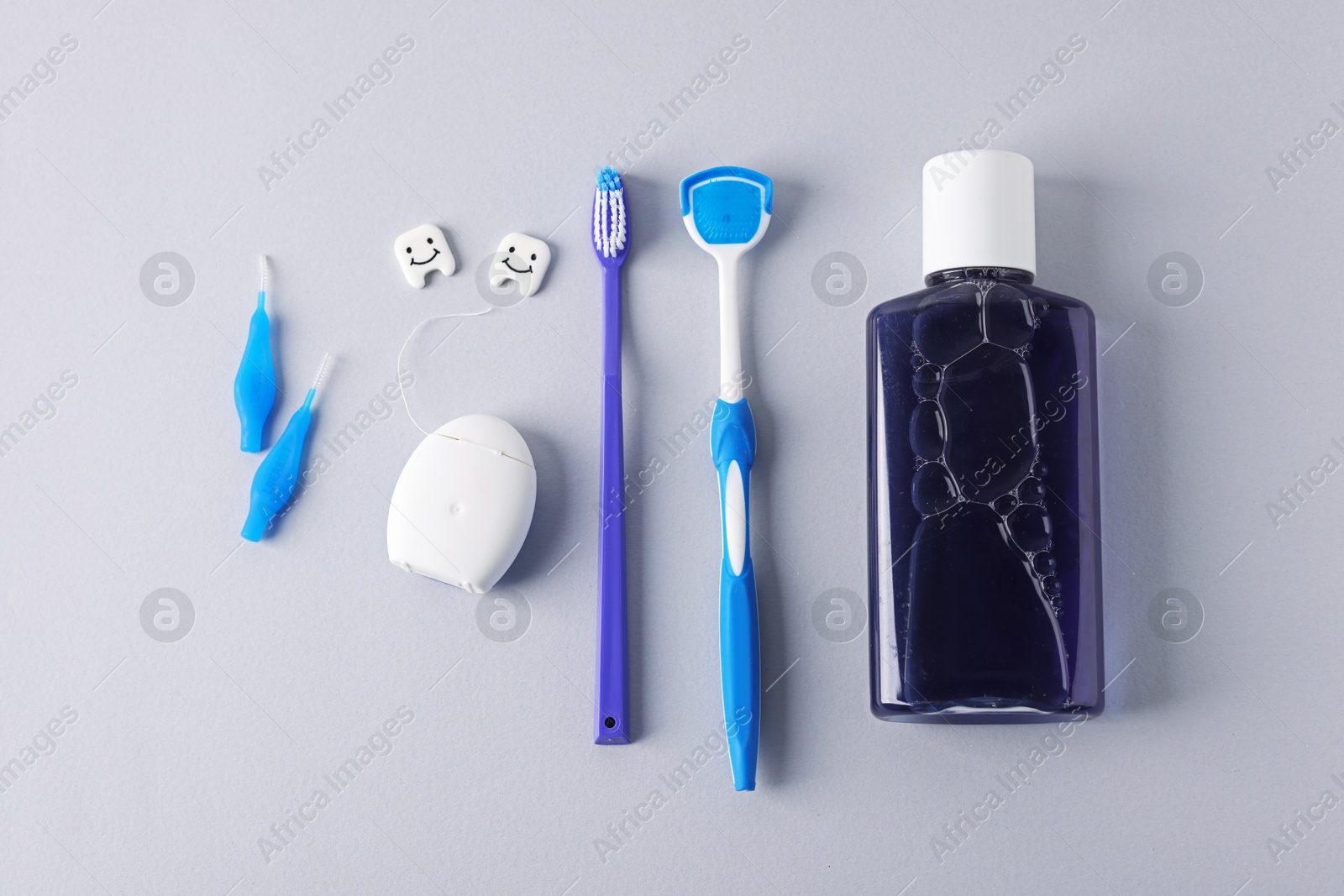 Different oral care products and teeth models on light grey background, flat lay Photo of Different oral care products and teeth models on light grey background, flat lay