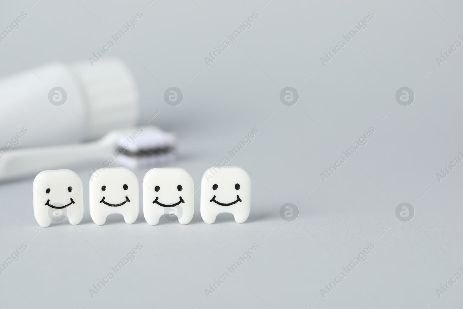 Different oral care products and teeth models on light grey background, closeup. Space for text Photo of Different oral care products and teeth models on light grey background, closeup. Space for text