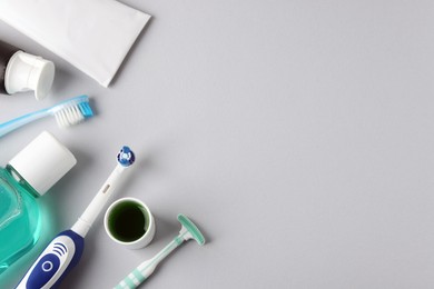 Photo of Different oral care products on light grey background, flat lay. Space for text