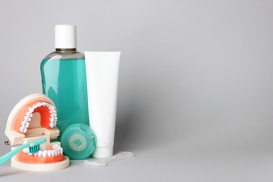 Photo of Different oral care products on light grey background, space for text