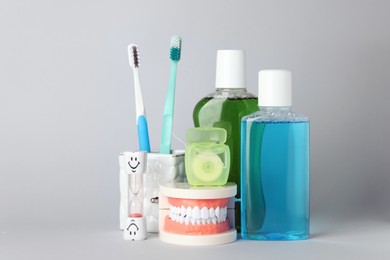Photo of Different oral care products on light grey background