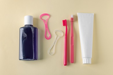 Photo of Different oral care products on beige background, flat lay