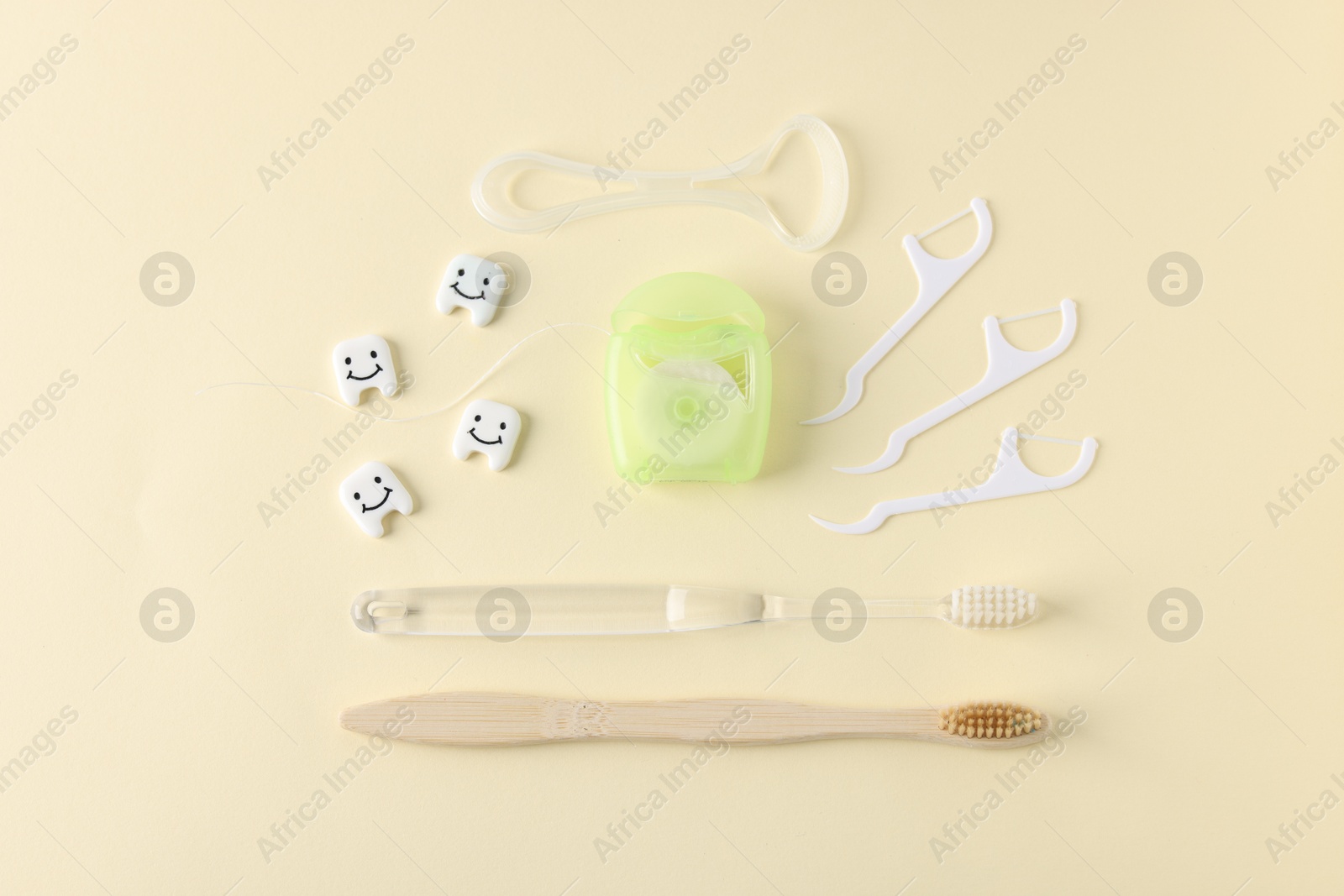Different oral care products and teeth models on beige background, flat lay Photo of Different oral care products and teeth models on beige background, flat lay