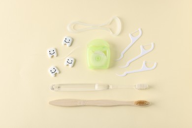 Photo of Different oral care products and teeth models on beige background, flat lay