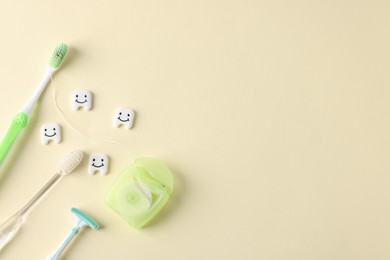 Photo of Different oral care products and teeth models on beige background, flat lay. Space for text